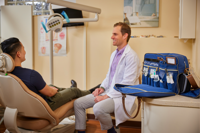 Doctor with patient with doctor bag open with medical equipment 